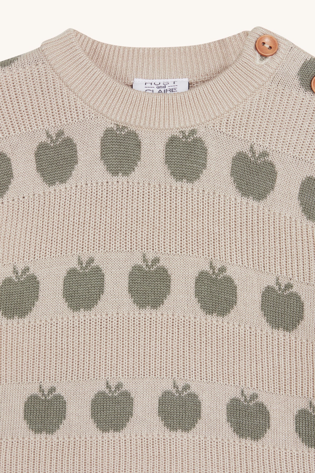 Nahaufnahme des Apfel-Prints in Mint und der praktischen Knopfdetails am Hust & Claire Pos Pullover Seagrass.