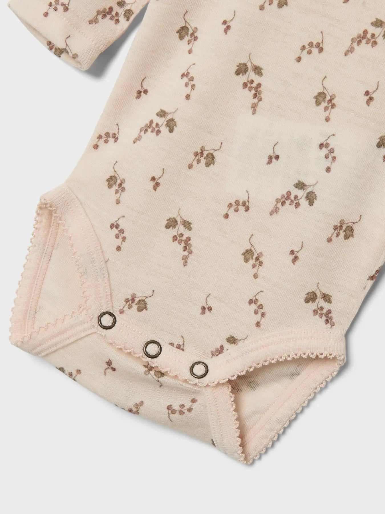 Die Detailaufnahme zeigt den unteren Teil des Lil' Atelier Bodys mit feinem Traubenmuster aus Winterthur.