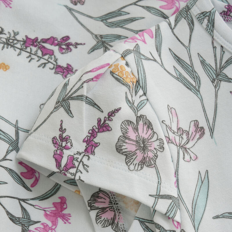 Detailaufnahme des floralen Musters auf dem Minymo T-Shirt, hergestellt aus nachhaltiger Baumwoll- und Modal-Mischung.