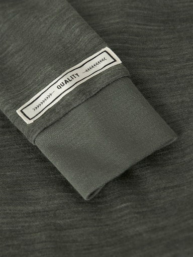 Detailaufnahme Knopf und Stoffstruktur eines Woll-Langarmshirts in Grün, Bärechind Winterthur Zürich Schweiz