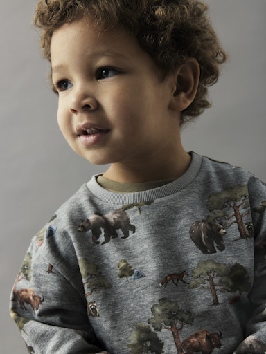 Kind trägt graues Sweatshirt mit Waldtiere-Print (Bison, Bären, Füchse, Zelte), Bio-Baumwolle, Bärechind Winterthur Zürich Schweiz