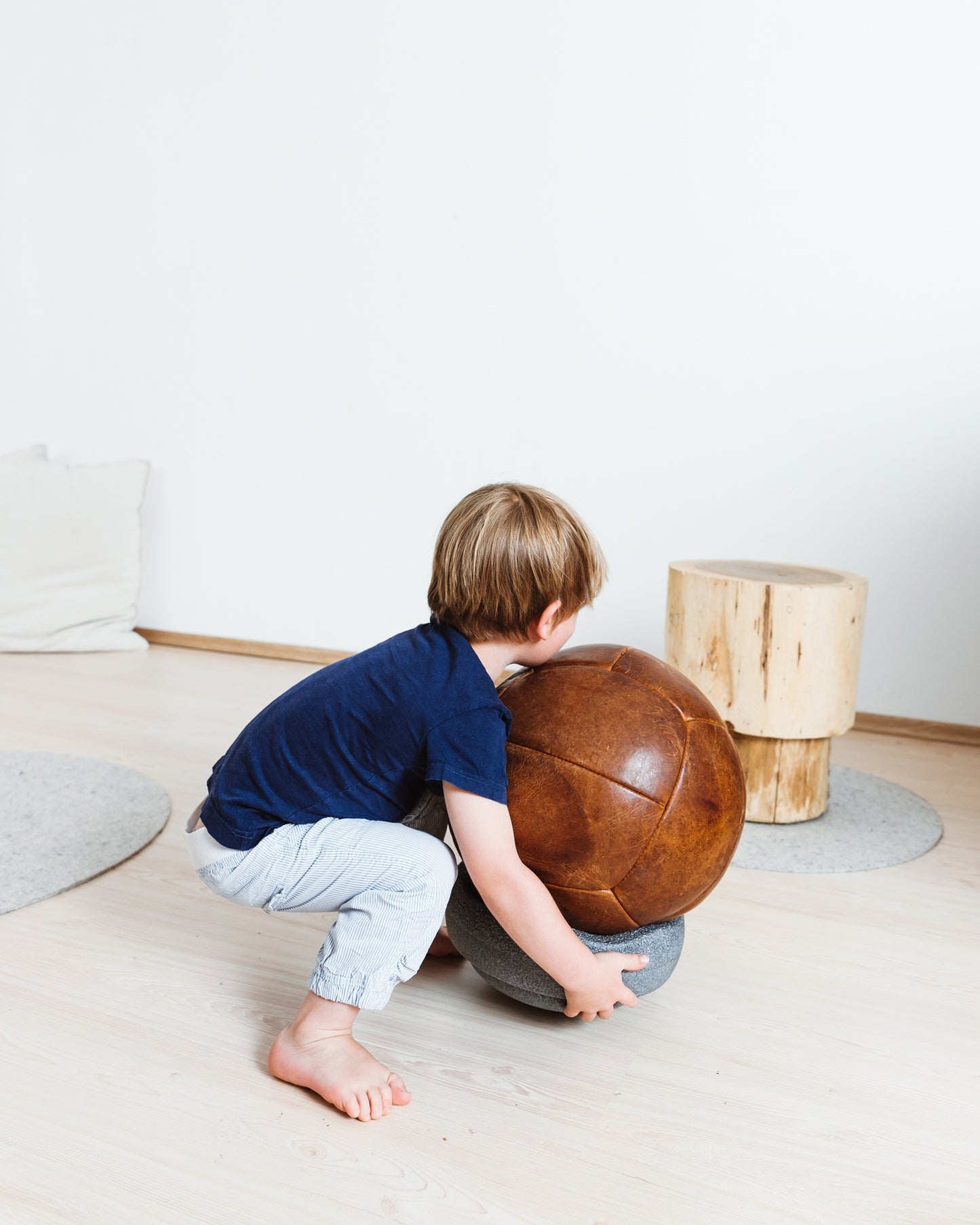 Kind in Bewegung mit grauem Stapelstein – vielseitiges Spielzeug für drinnen und draussen im Bärechind Zürich