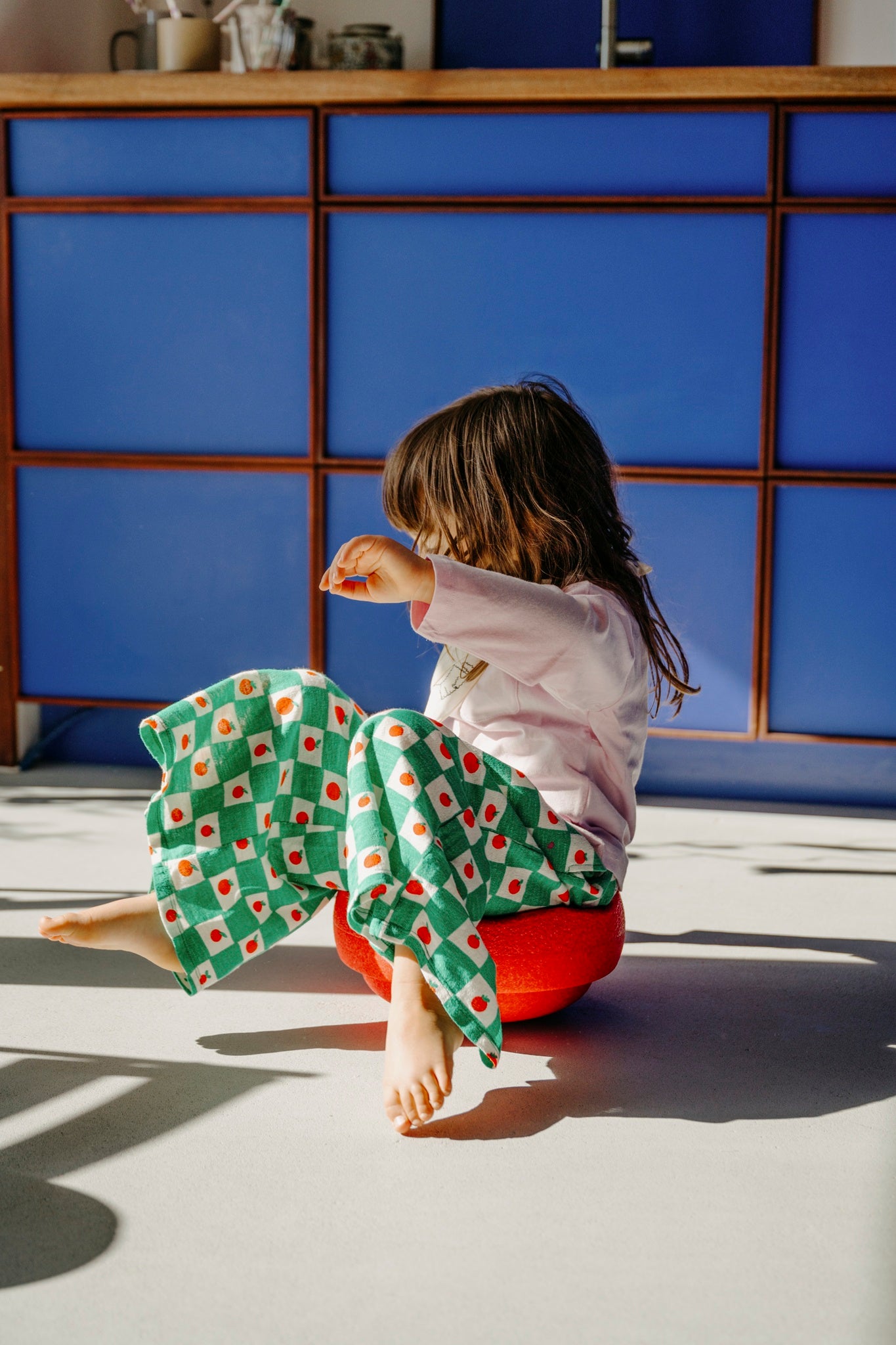 Kind in Bewegung mit rotem Stapelstein – entdeckt im Bärechind, dem Kinderladen in Winterthur, Zürich