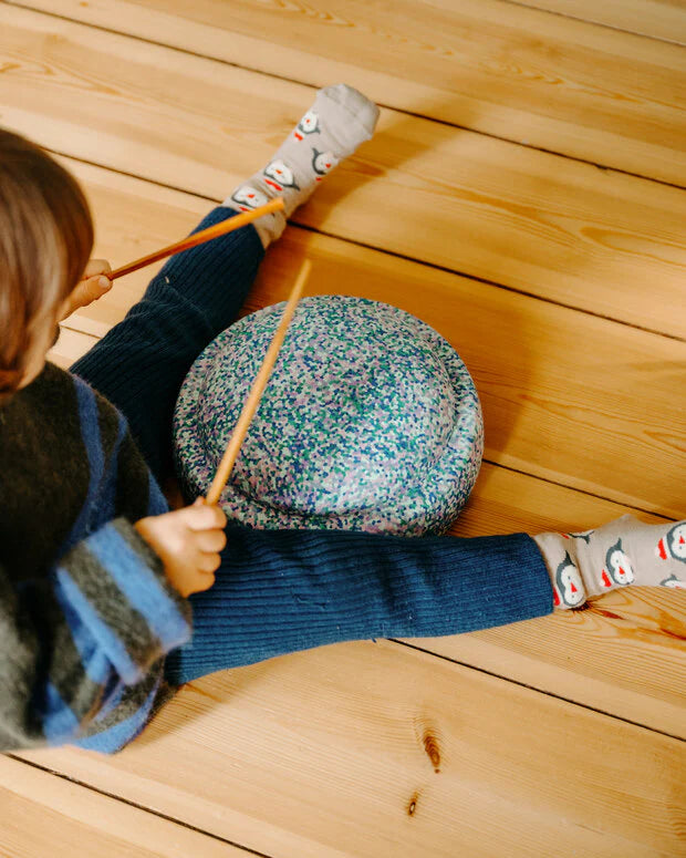 Kind trommelt auf Stapelstein– kreative Spielideen aus nachhaltigem Material, erhältlich in der Schweiz