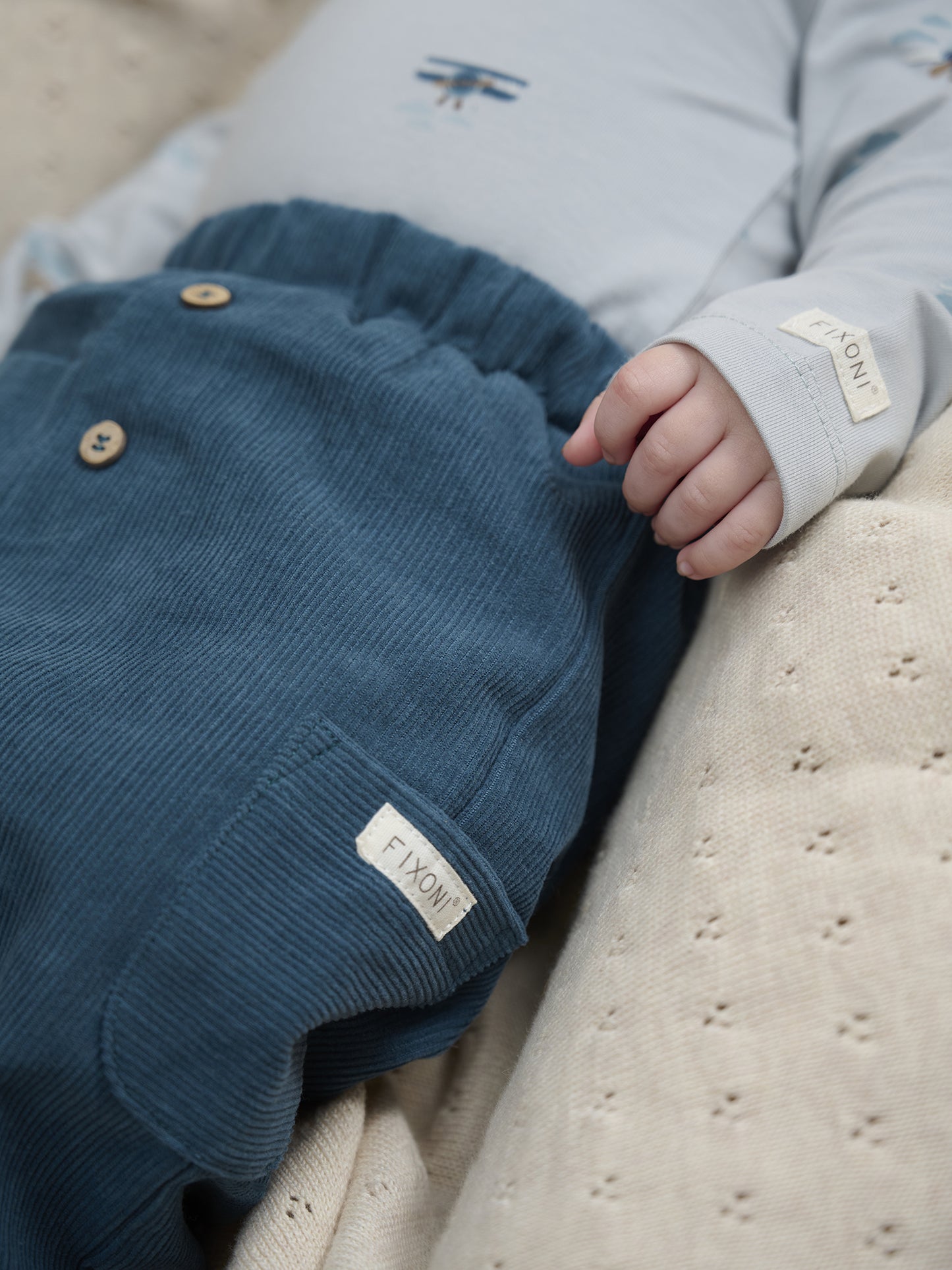 Baby trägt dunkelblaue Fixoni Cordhose mit Futter – erhältlich im Bärechind in Winterthur, Zürich, Schweiz