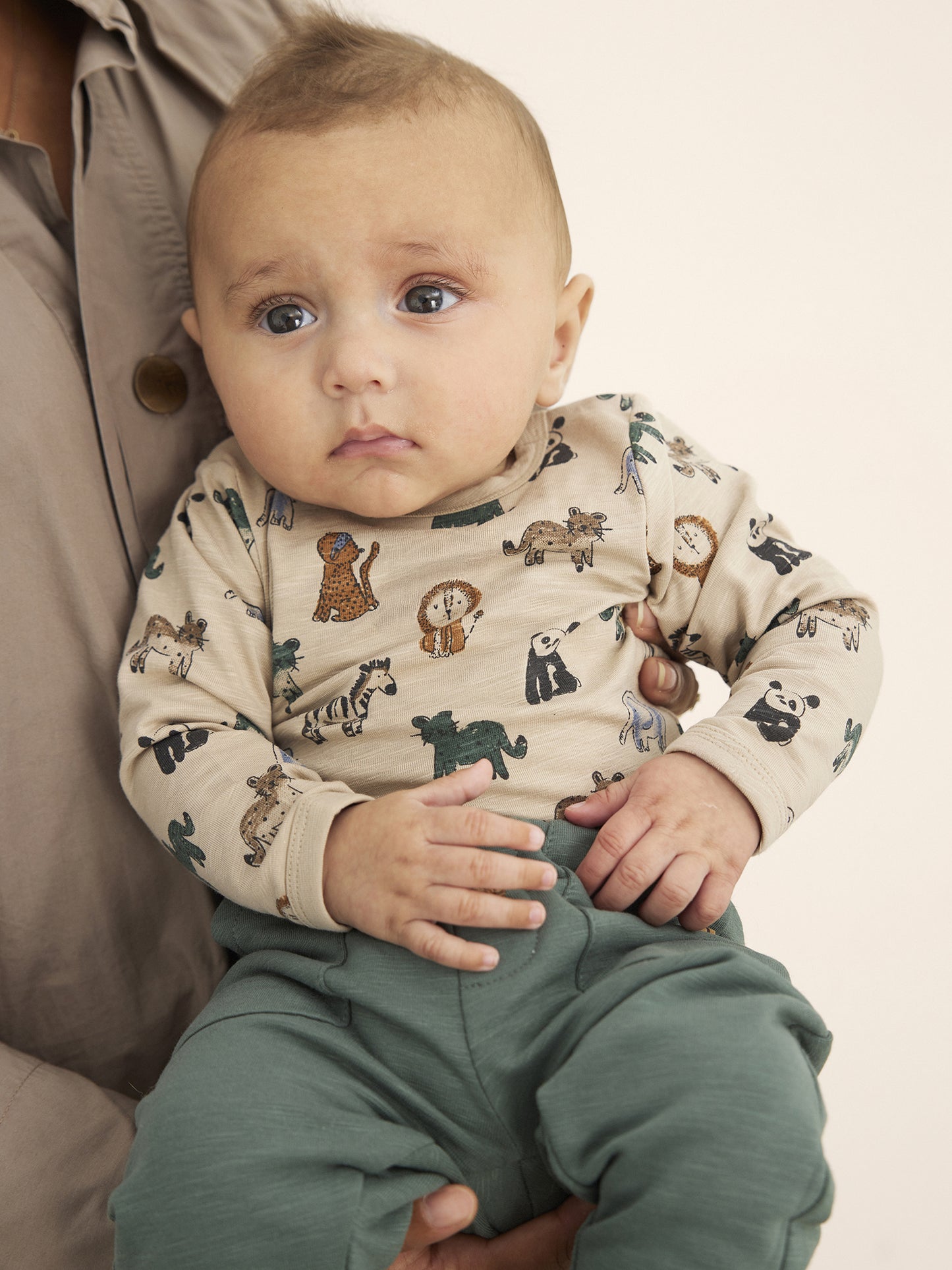 Baby trägt Minymo Sweatpants in Dunkelgrün – bequemer Alltagslook aus Bio-Baumwolle
