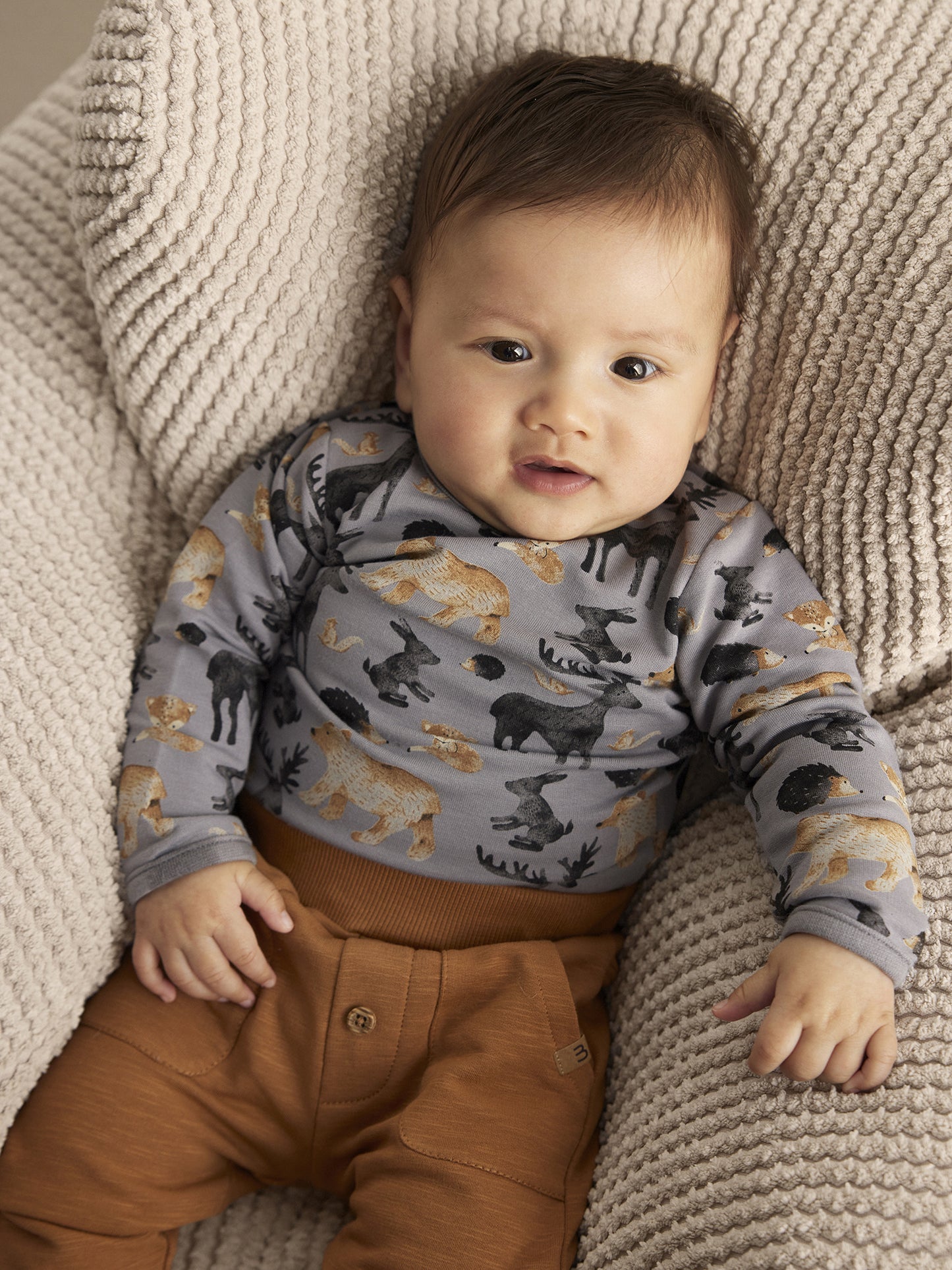 Baby trägt Minymo Sweatpants in Braun – bequem und stilvoll in Bio-Qualität