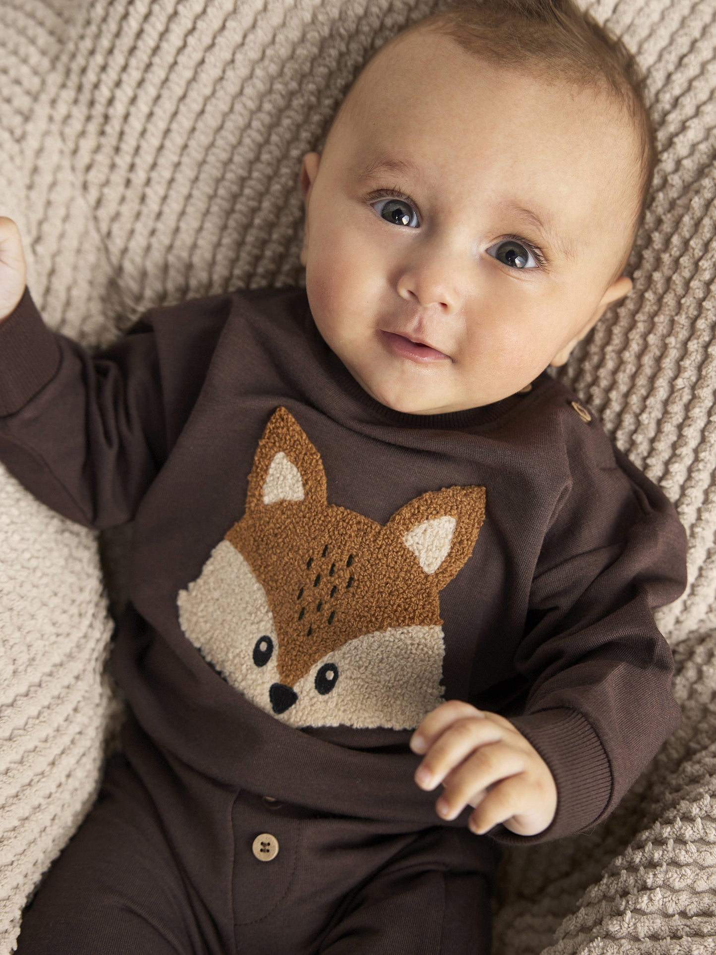 Baby trägt Minymo Sweatpants in Braun – weiche Biohose im Alltag