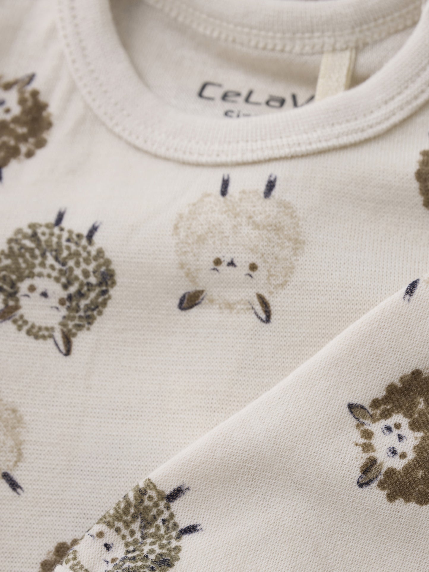 Stoffdetail mit niedlichen Schafen auf dem CeLaVi Langarmbody – im Bärechind in Winterthur, Zürich, Schweiz