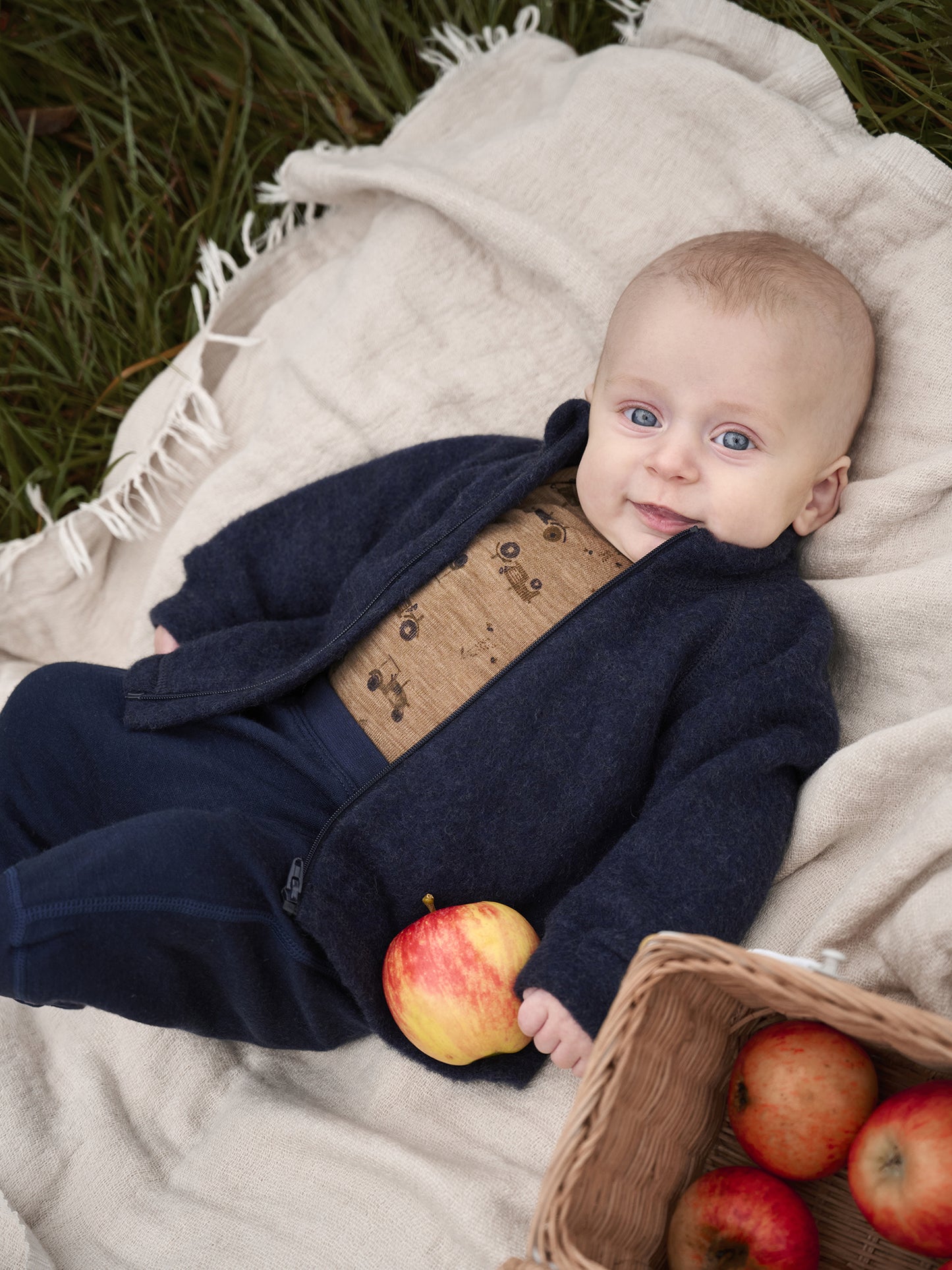 Baby trägt CeLaVi Langarmbody aus Wolle in cocoa creme mit Traktorprint, erhältlich im Bärechind in Winterthur, Zürich Schweiz.