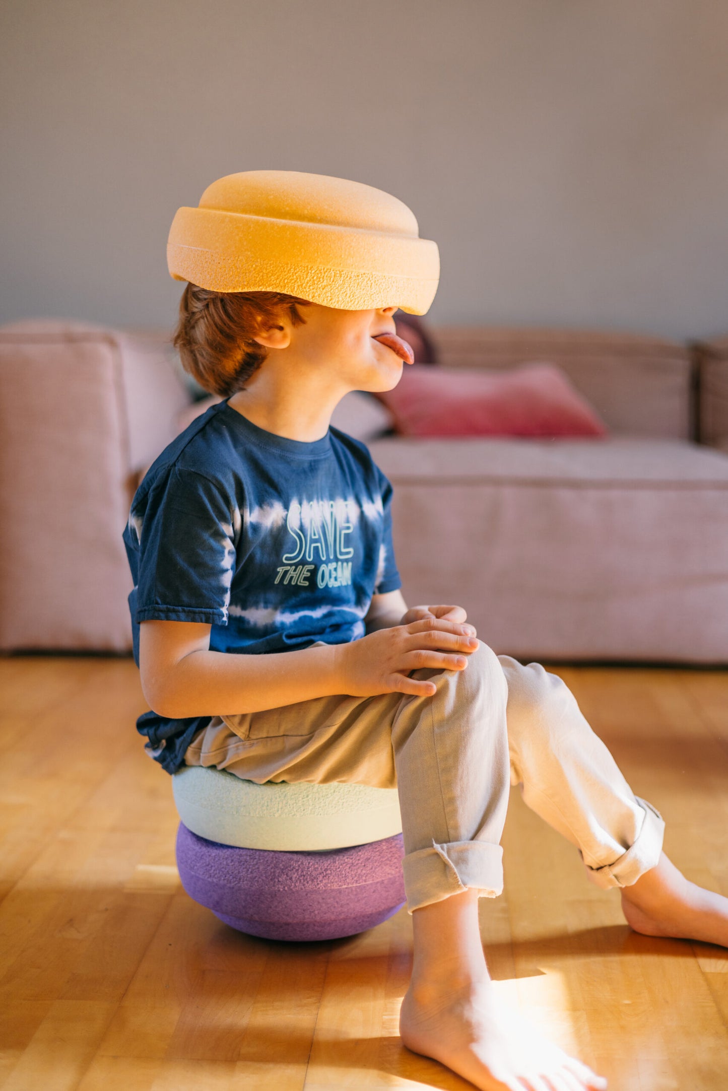 Chind balanciert Stapelstein in Light Orange – spielerisch unterwegs in Winti