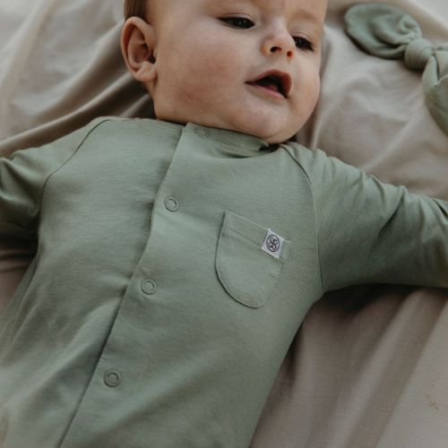 Baby trägt nachhaltigen Cloby Strampler aus Bio-Baumwolle in Grün