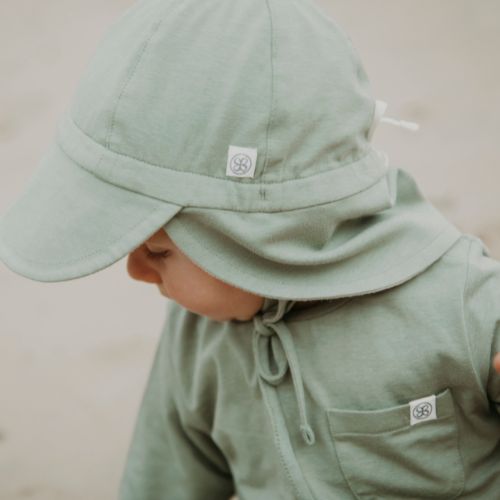 Baby trägt Cloby UV-Sonnenhut in Olive – Weicher, atmungsaktiver Sonnenhut mit UPF 50+ Schutz für empfindliche Babyhaut. Perfekt für sonnige Tage. Jetzt in Winterthur, Zürich, Schweiz erhältlich.