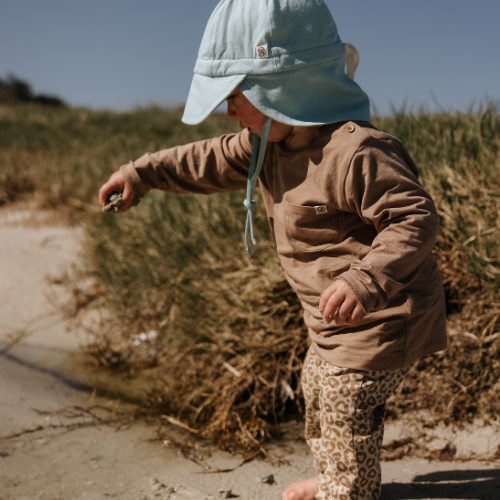 Baby trägt Cloby UV-Sonnenhut in Sea Blue mit Wendedesign in Sandy Beach. Leichter, atmungsaktiver Sonnenhut mit UPF 50+ Schutz. Jetzt in Winterthur, Zürich, Schweiz erhältlich.