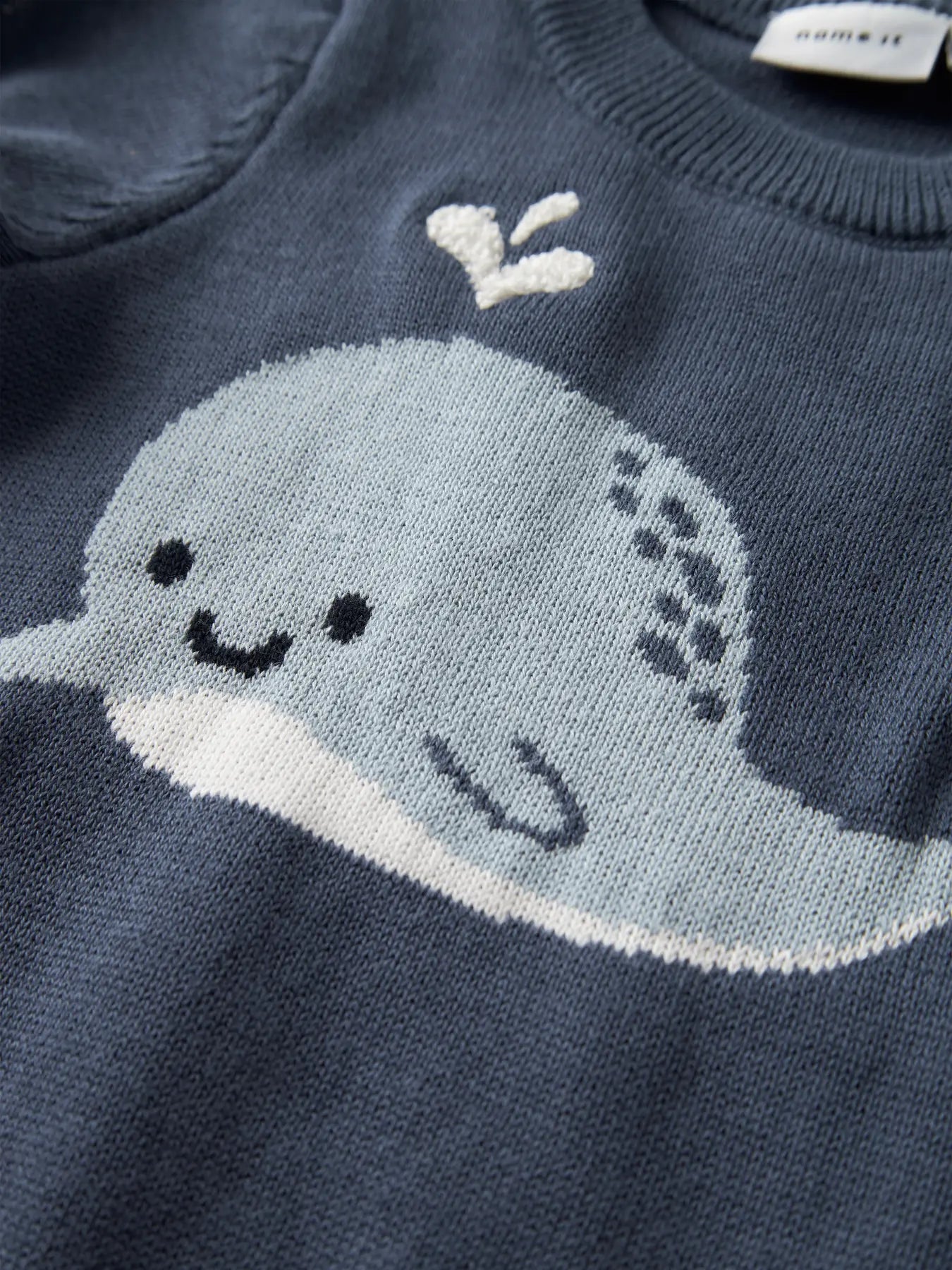 Detailaufnahme Wal Motiv auf Baby Strickpullover aus Baumwolle, erhältlich bei Bärechind Winterthur Zürich Schweiz.