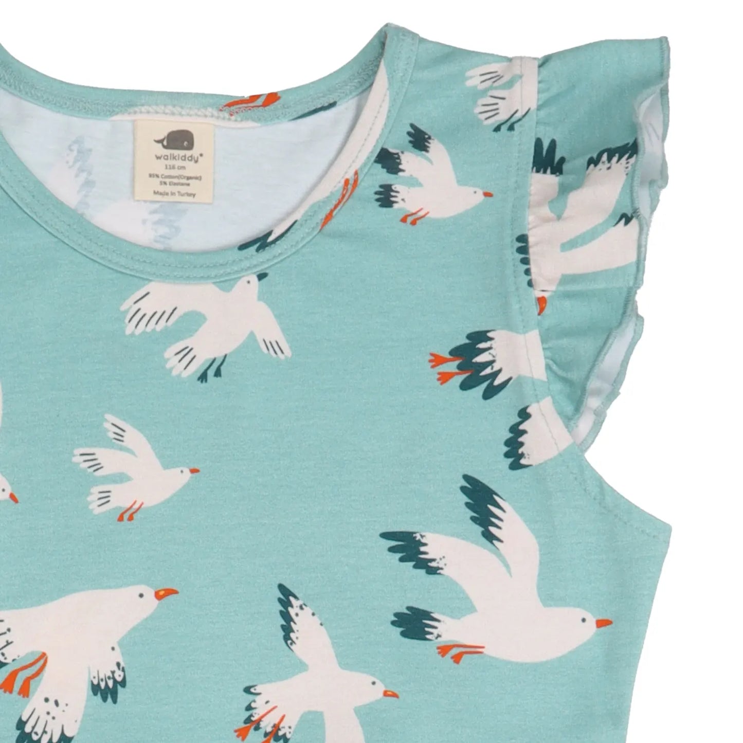 Nahaufnahme der Rüschen und des Möwen-Motivs auf einem Kinderkleid aus nachhaltiger Bio-Baumwolle.