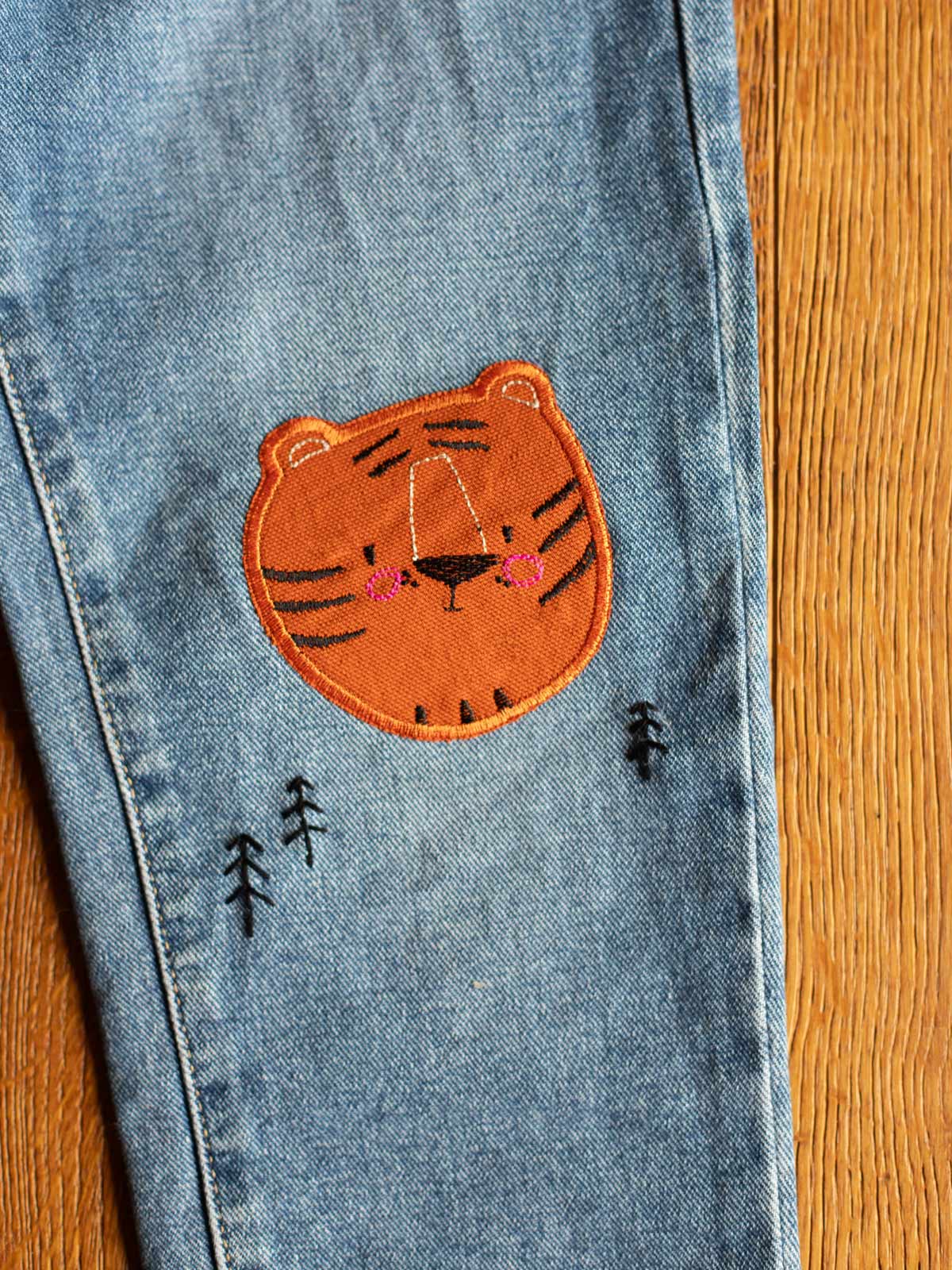Aufgebügelter Tiger-Flicken auf Jeans – nachhaltige Lösung für Reparaturen, Schweiz