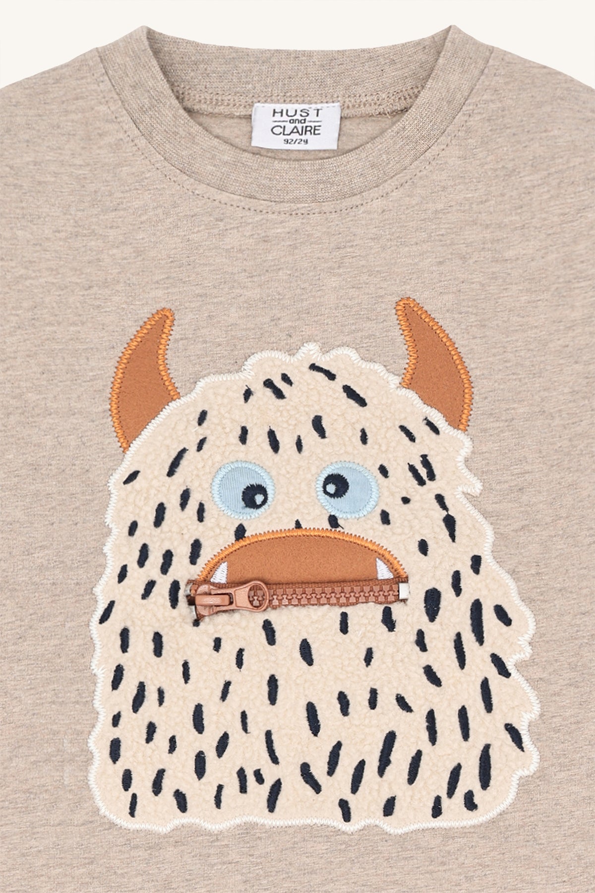 Beiger Kinderpullover mit Monster-Motiv von Hust&Claire, aus Bio-Baumwolle, erhältlich im Bärechind Winterthur, Zürich Schweiz.