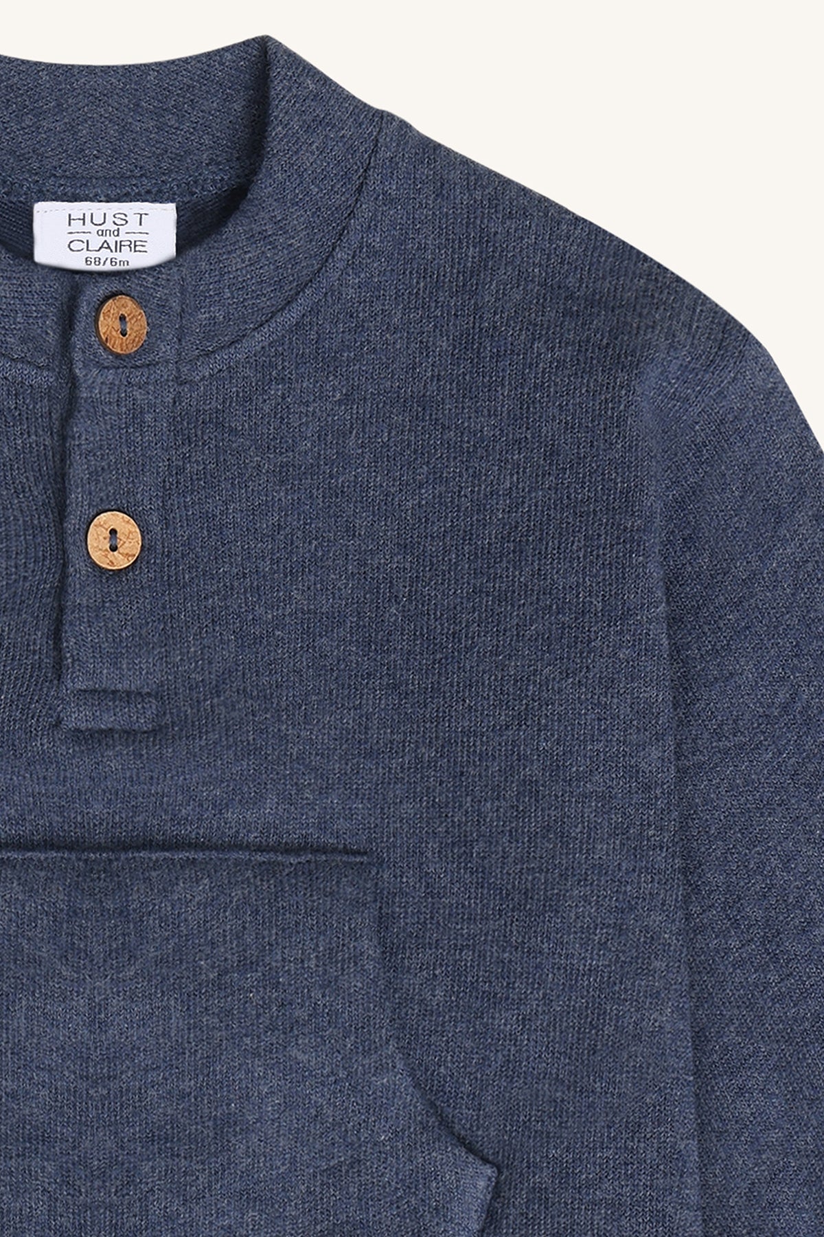 Nahaufnahme der Holzknöpfe und Strickstruktur am Ausschnitt des Sigurt Pullovers