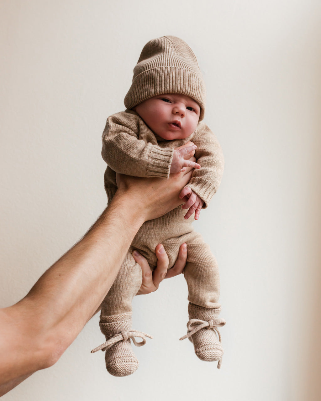Baby trägt den Hvid Baby Strickpullover Georgette in Sand, erhältlich bei Bärechind