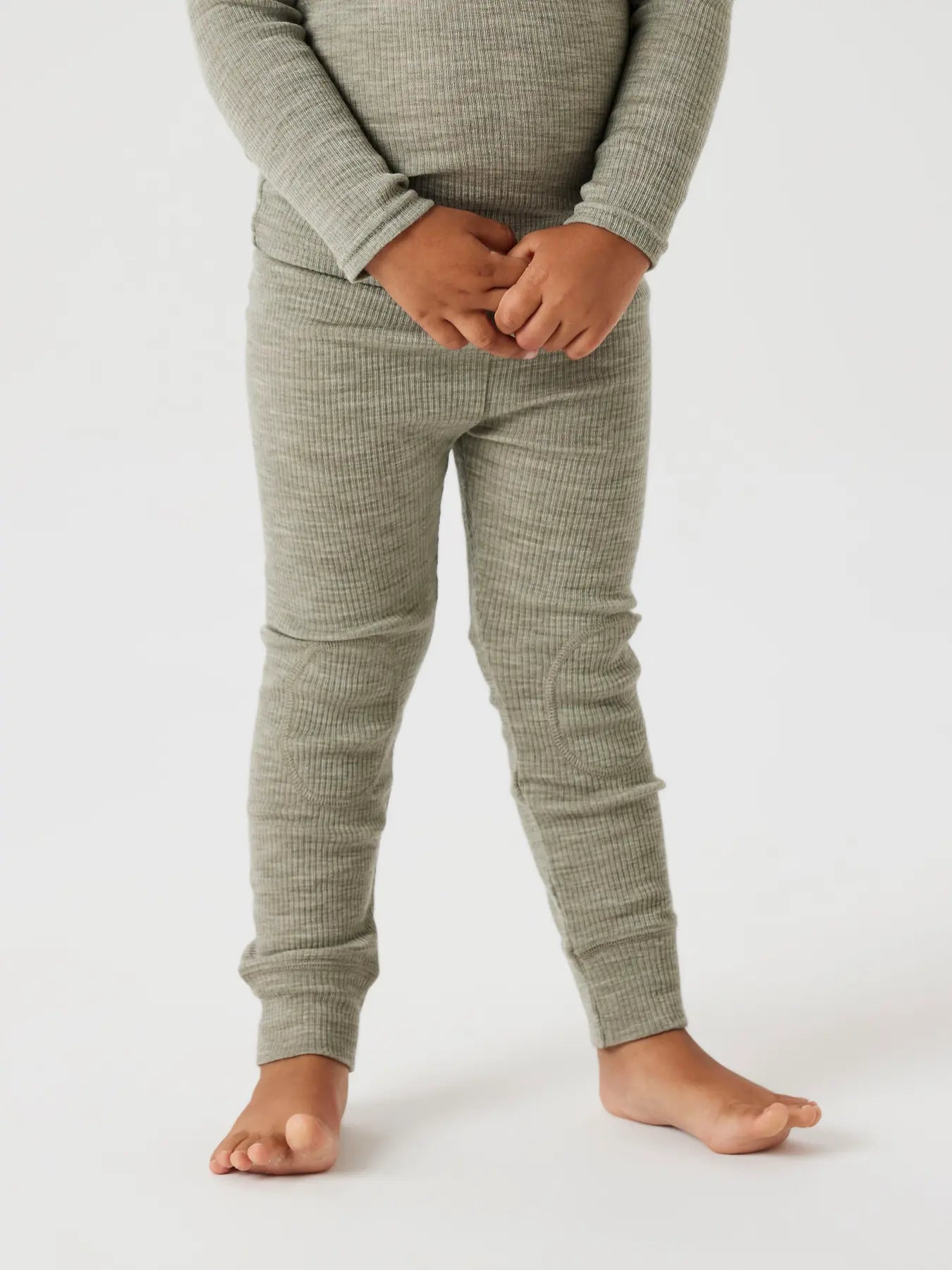 Kind trägt grün melierte Ripp-Leggings mit Kniepatches aus Wollmischung.