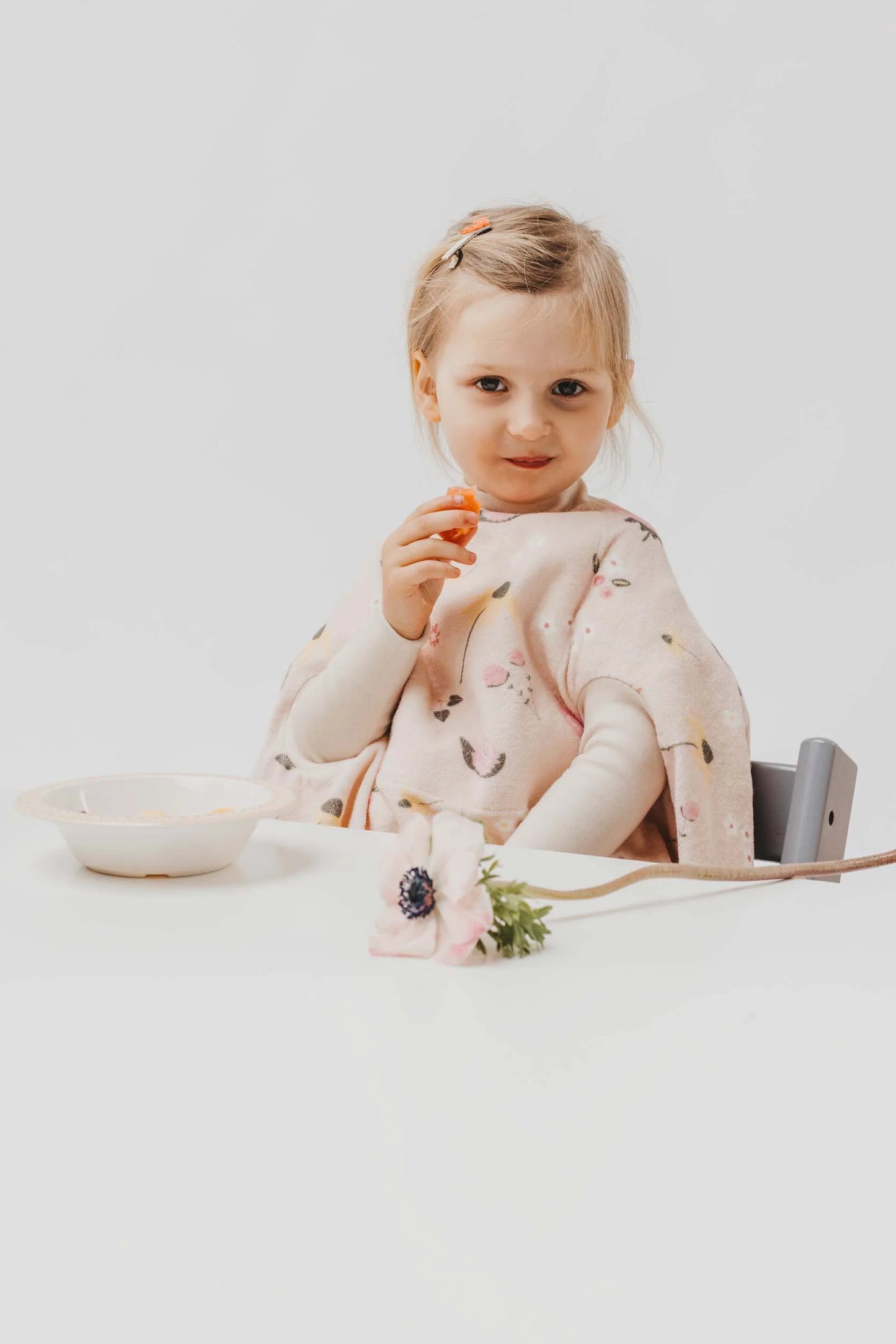 Kleinkind beim Essen trägt das wasserdichte Lätzchen „Boo“ im Wildflower-Design von Little Casimir