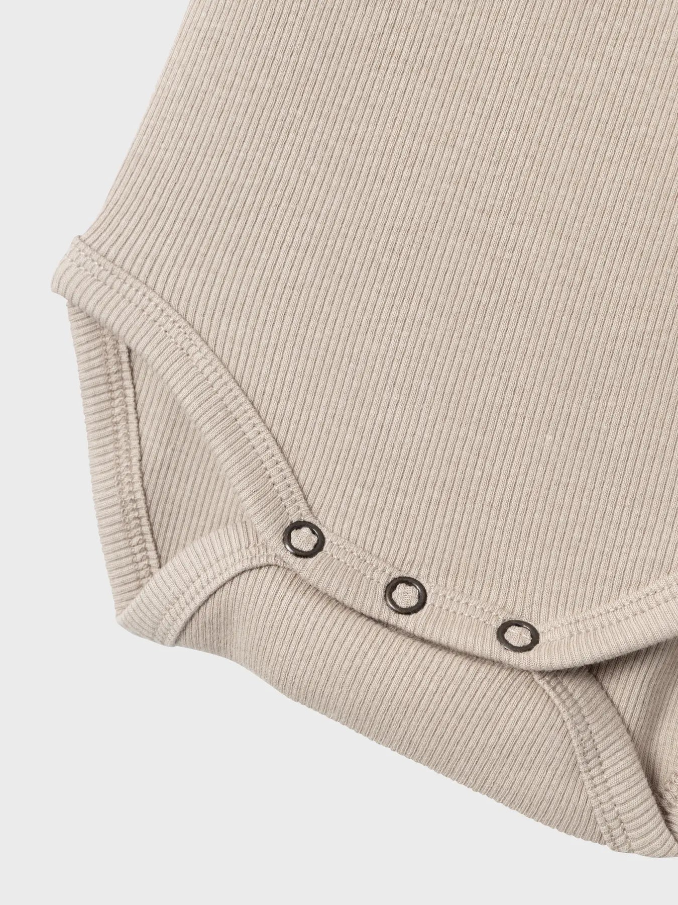 Detailaufnahme der praktischen Druckknöpfe am Body von name it – weich & funktional