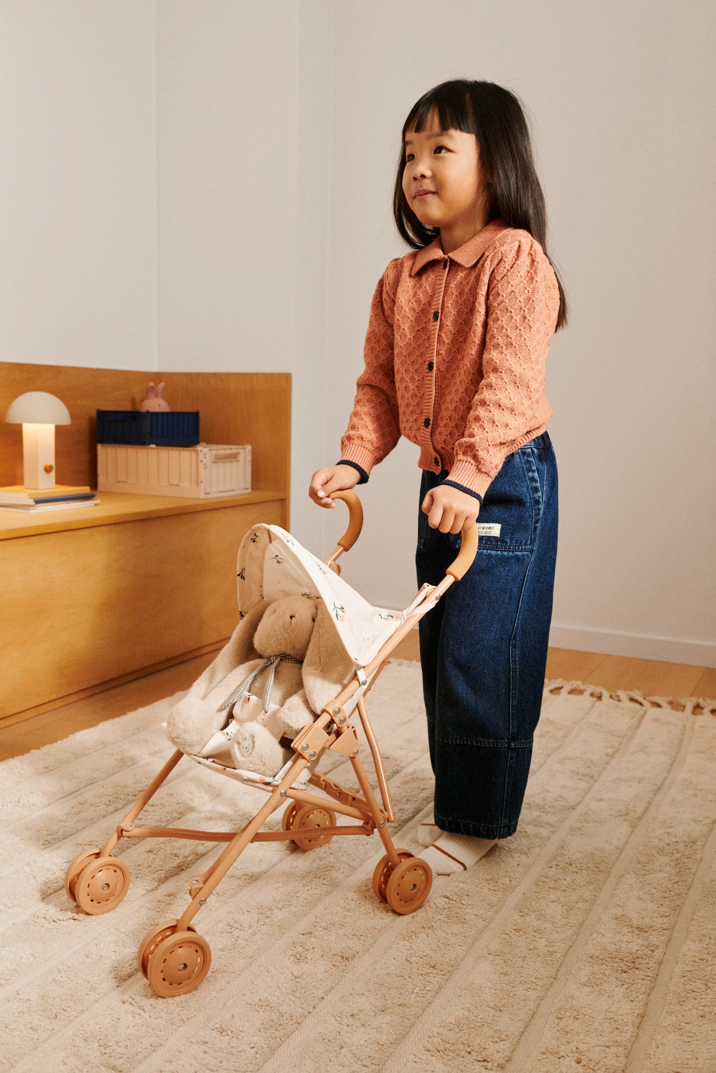 Kind spielt mit dem LIEWOOD Puppenwagen Elsie – ideales Rollenspielzeug.