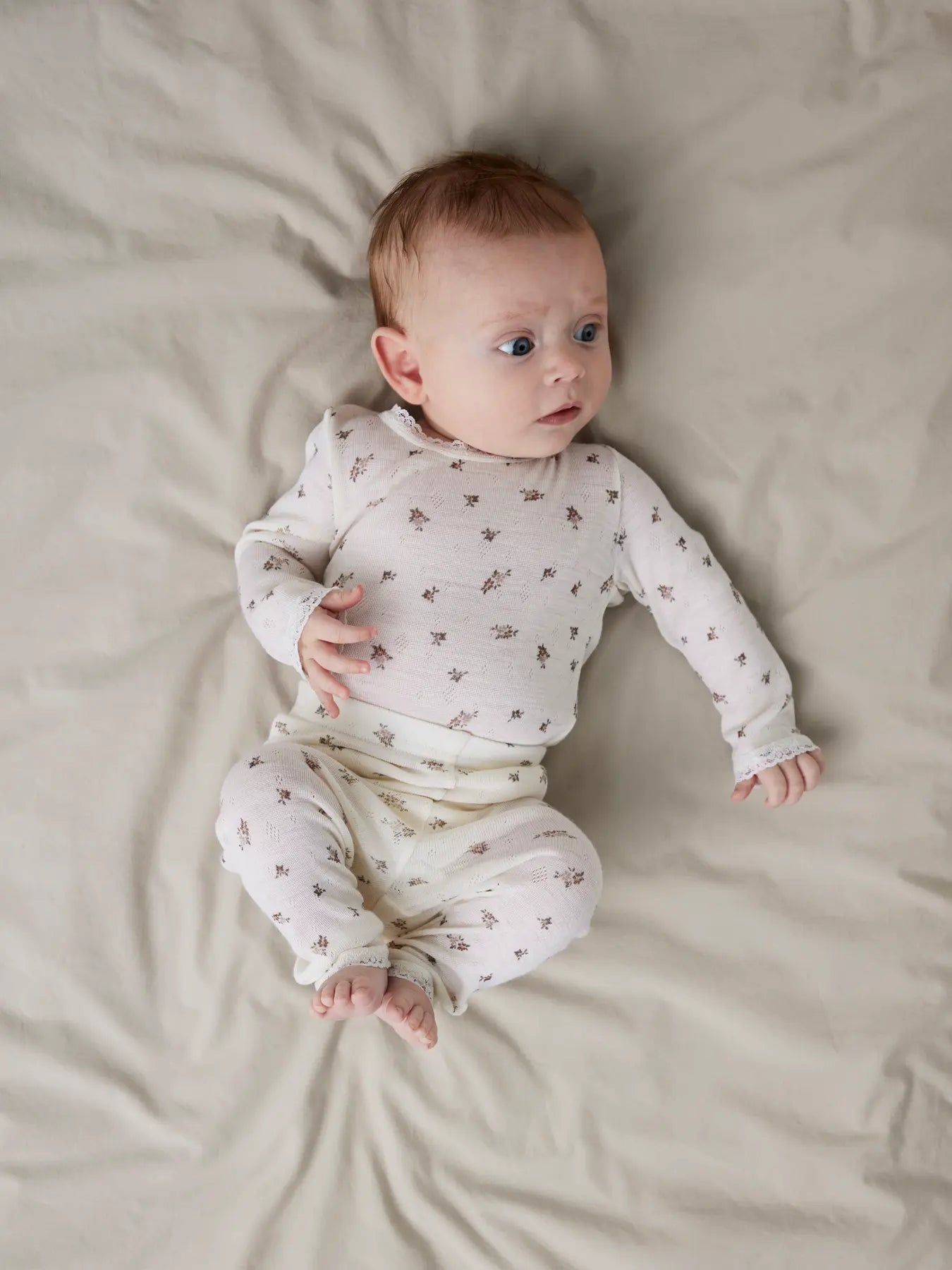 Ein Baby trägt Lil'Atelier Leggings mit zartem Blumenmuster und Spitzenabschluss in Winterthur.