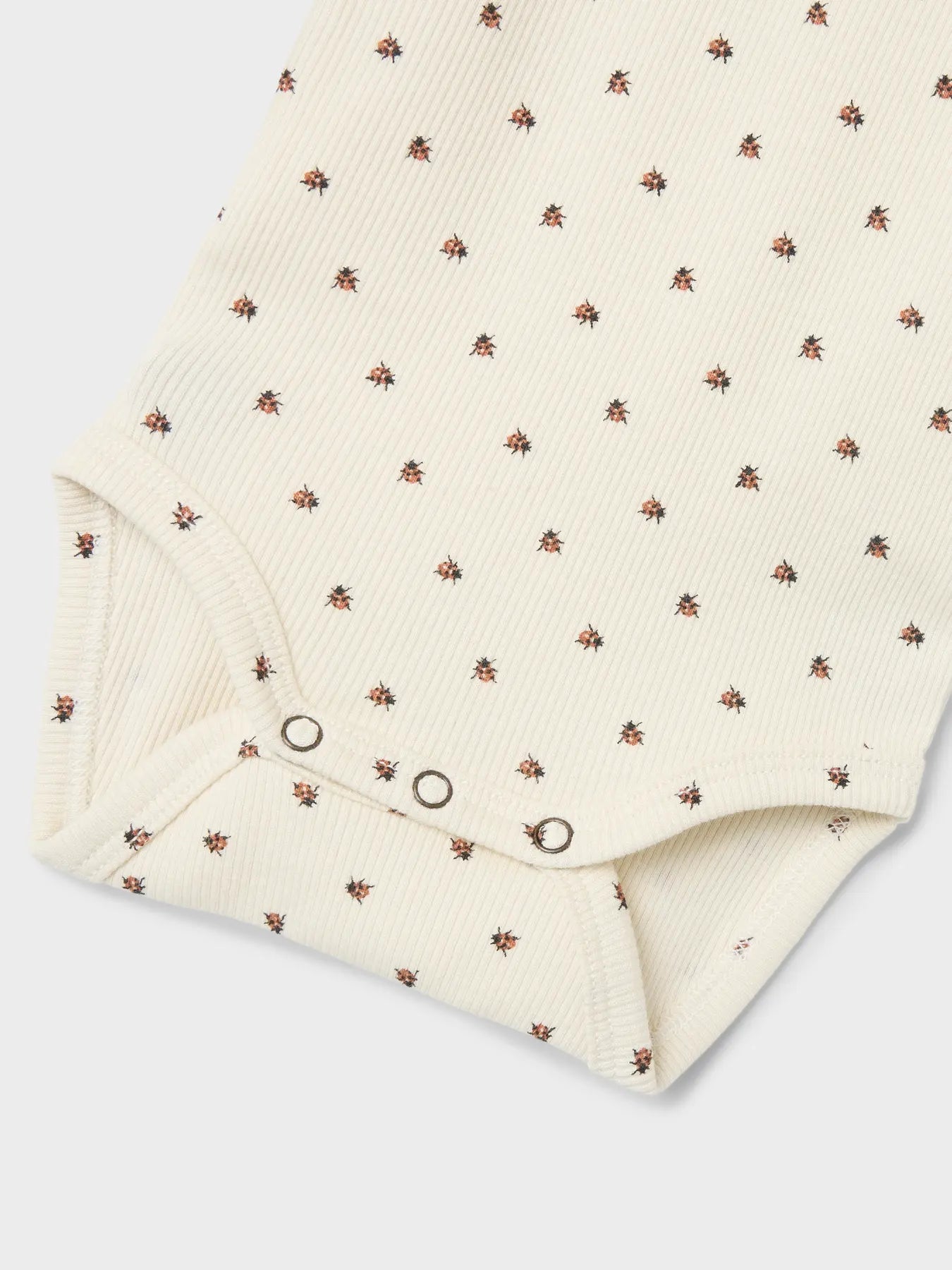 Detailansicht des Lil' Atelier Babybodys mit Marienkäfer-Print aus TENCEL™ – erhältlich bei Bärechind Winterthur.