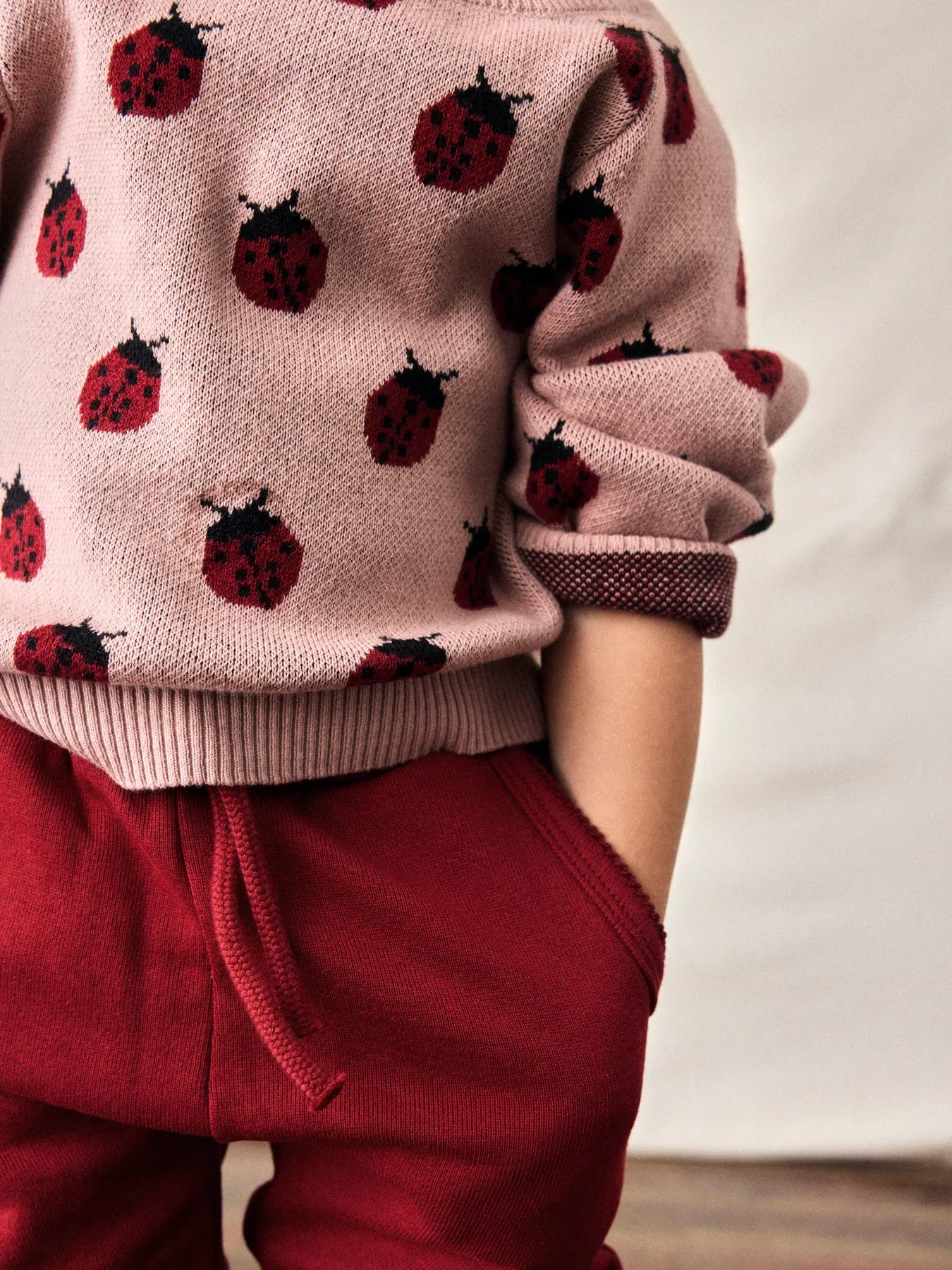 Kind trägt Lil'Atelier Pullover mit Marienkäfer-Muster aus Bio-Baumwolle bei Bärechind in Winterthur, Zürich, Schweiz.