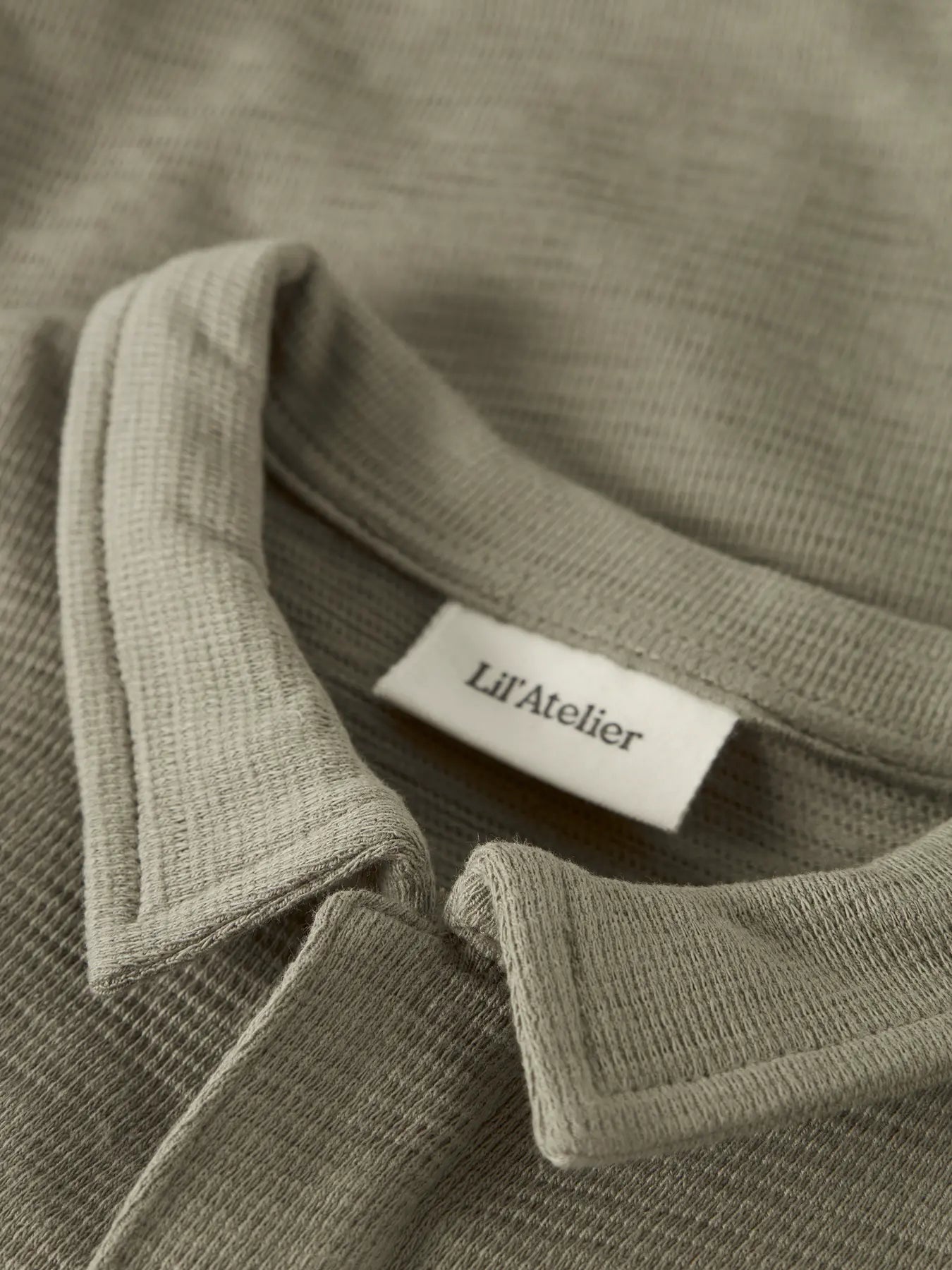 Detail Polokragen Baby Body in olive aus Baumwolle von Lil' Atelier im Bärechind Kinderladen Bärechind Winterthur Zürich Schweiz