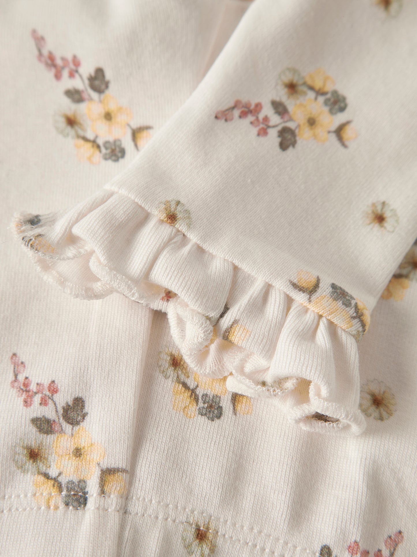 Detail der Lil’Atelier Baby Leggings mit floralem Print und Rüschen am Beinabschluss