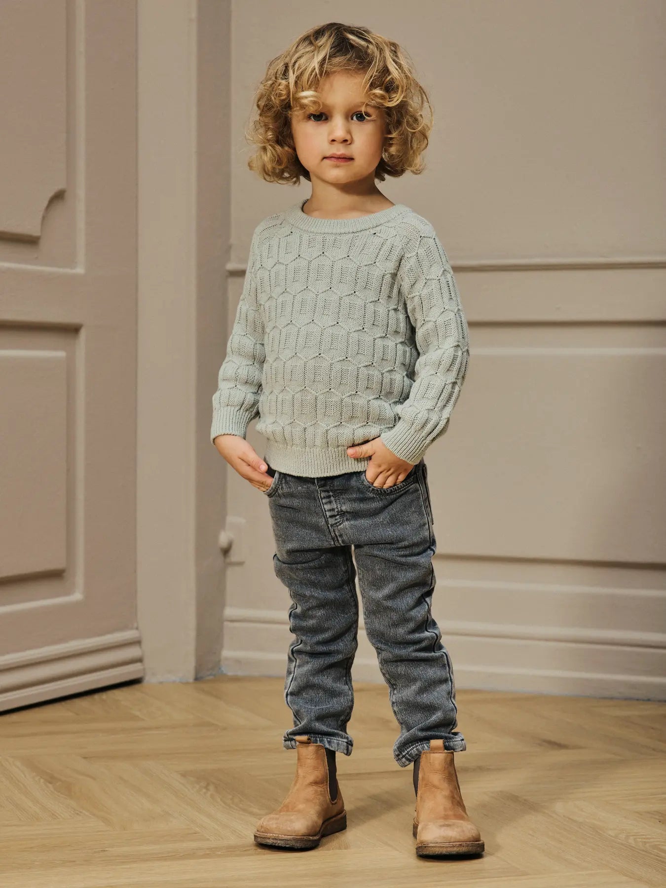 ind trägt hellgrünen Lil'Atelier Strickpullover aus Bio-Baumwolle – erhältlich bei Bärechind in Winterthur, Zürich Schweiz.