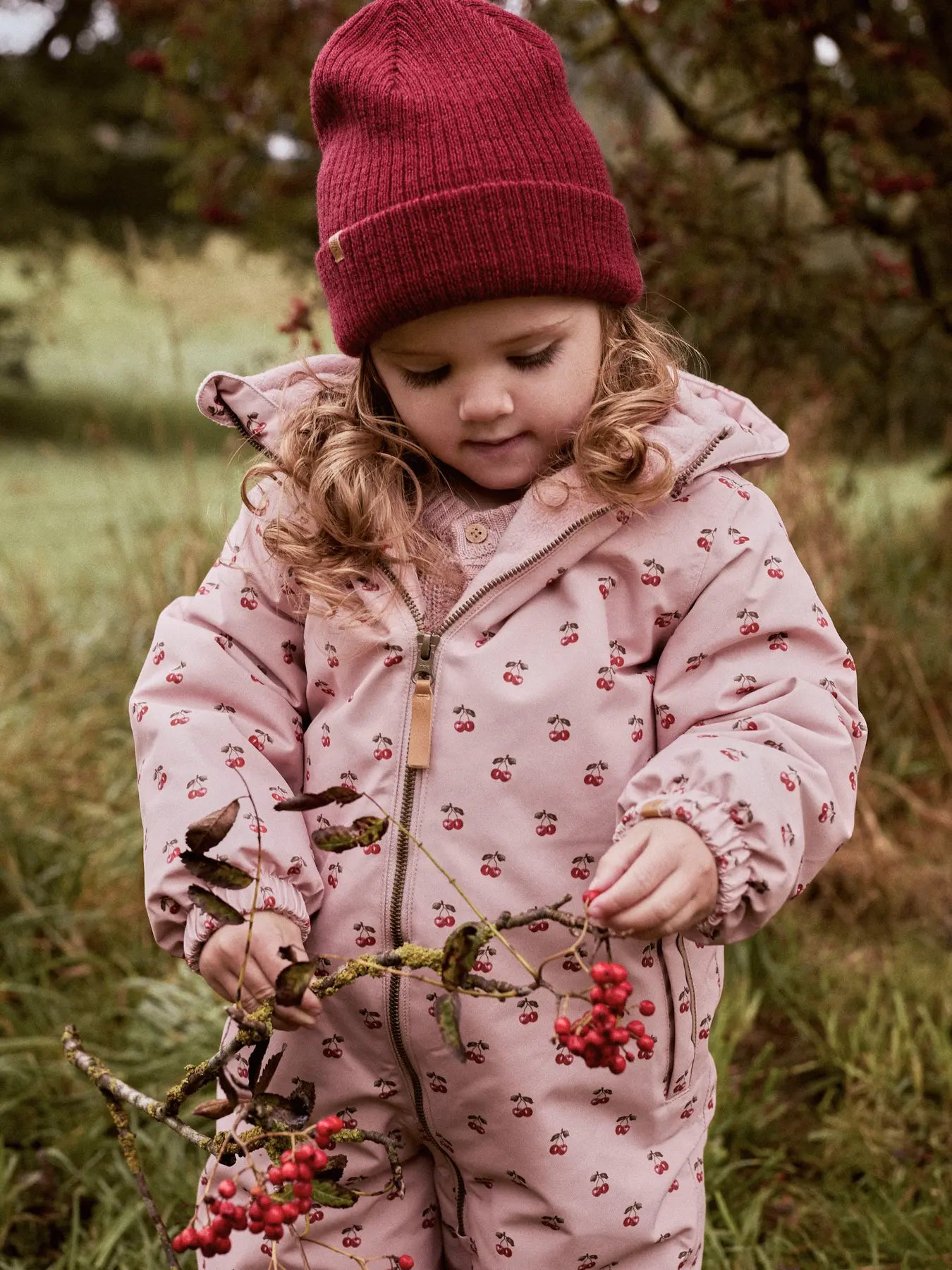 Kind mit roter Lil'Atelier Wollmütze im Freien – erhältlich bei Bärechind in Winterthur, Zürich Schweiz.