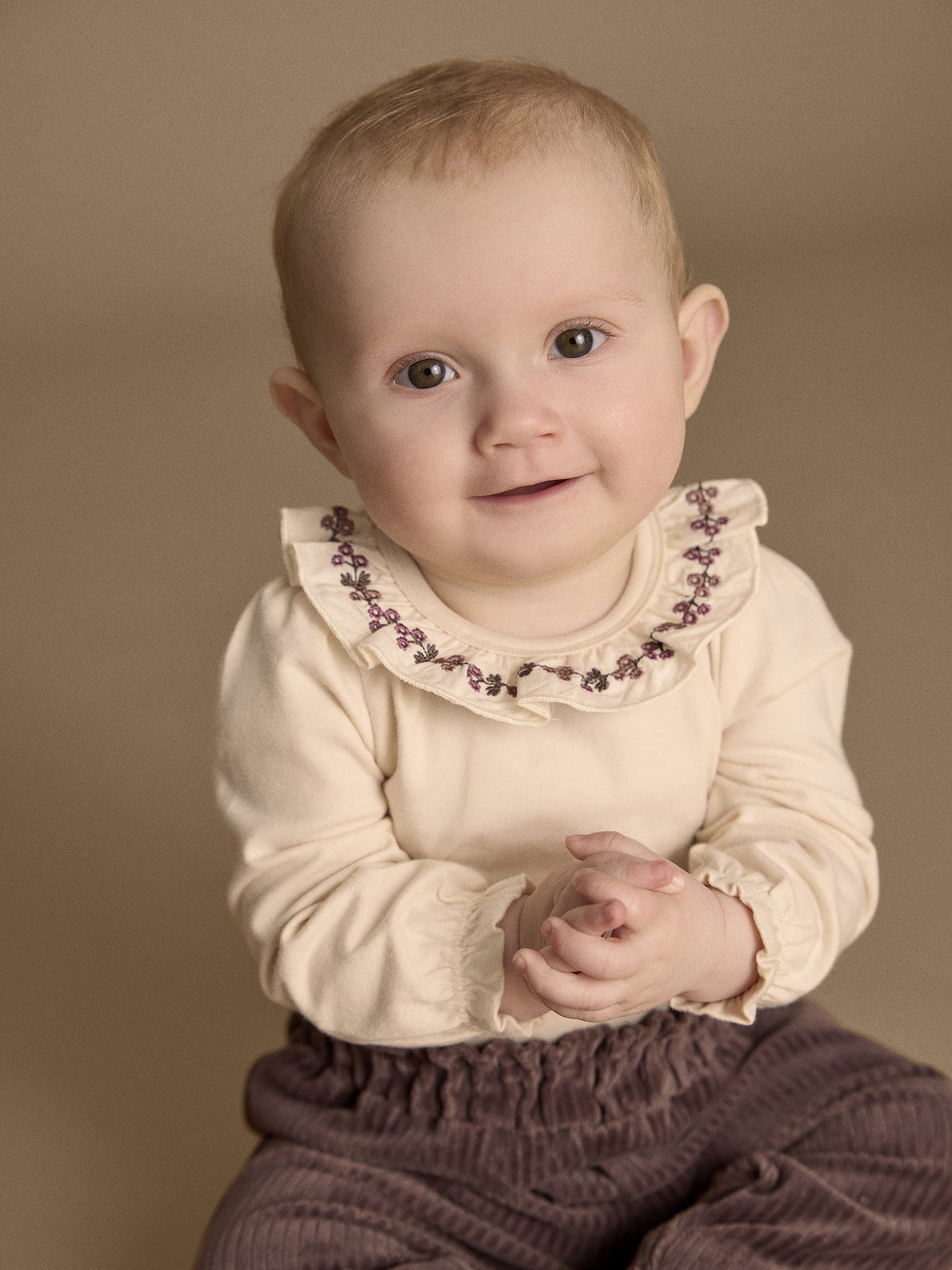 Baby trägt Minymo Cordhose in Plum Truffle