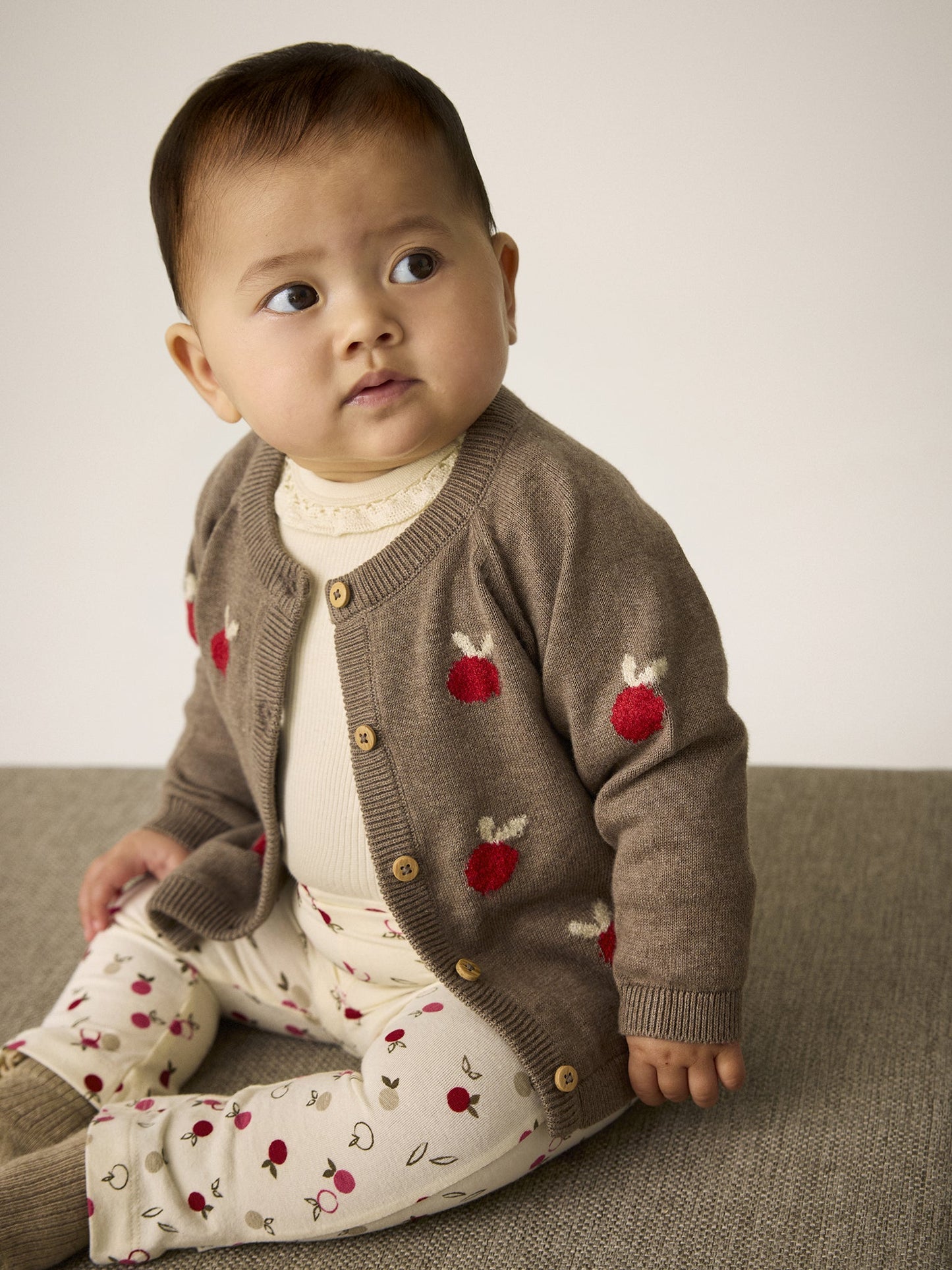 Baby trägt Minymo Strickjacke in Dark Brown Melange