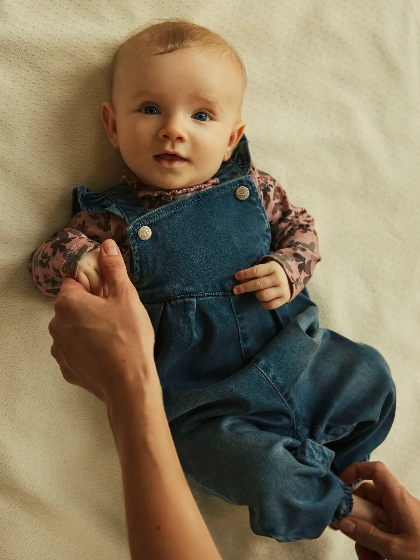 Baby trägt NAME IT Latzhose aus TENCEL™ in Jeansoptik – erhältlich bei Bärechind in Winterthur, Zürich, Schweiz.