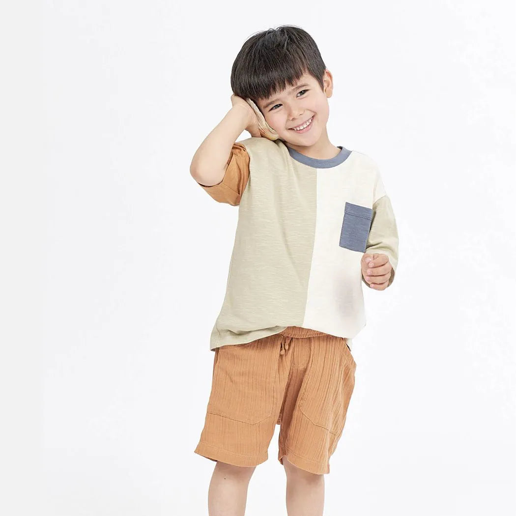 Kind trägt das OSWIN Shirt mit Colour-Blocking-Design aus Bio-Baumwolle, modernes & nachhaltiges Kinder-T-Shirt