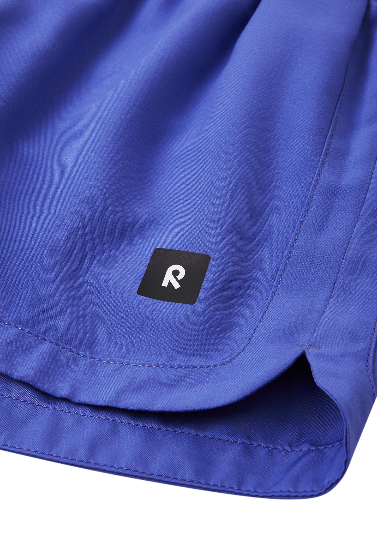 Detailaufnahme Logo & Saum der Reima Nauru Badeshorts – in Lila mit UV-Schutz
