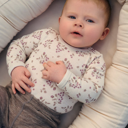 Baby trägt CeLaVi Body mit Blumenprint in Grape Shake
