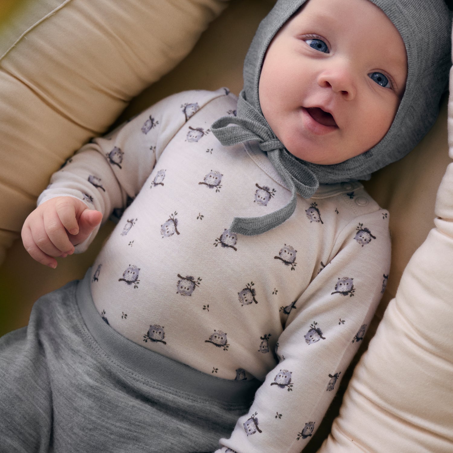 Baby trägt CeLaVi Body mit Eulenprint in Mocha Meringue