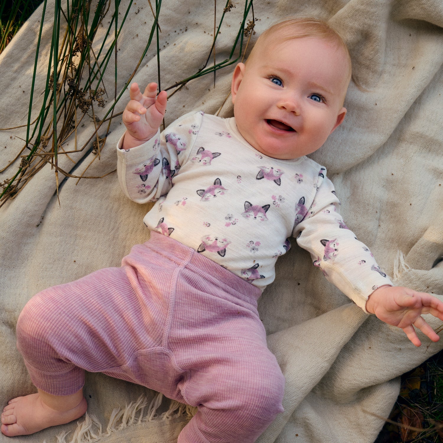 Baby trägt CeLaVi Merino Body mit Fuchsprint in Lilas im Alltag