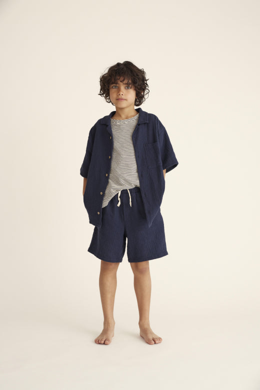 Kind trägt die Alex Bermudas von Cozmo in Navy, ideal für warme Sommertage und maximalen Komfort.