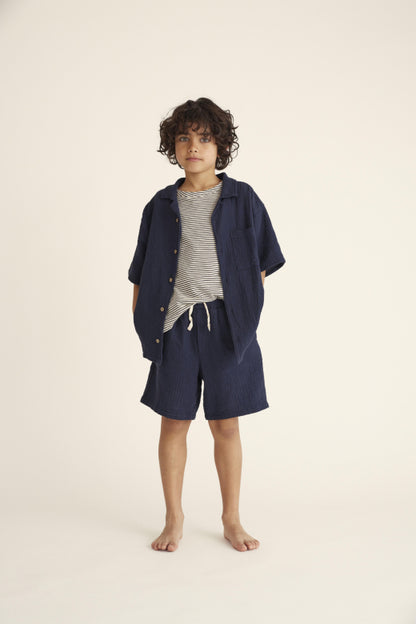 Kind trägt die Alex Bermudas von Cozmo in Navy, ideal für warme Sommertage und maximalen Komfort.