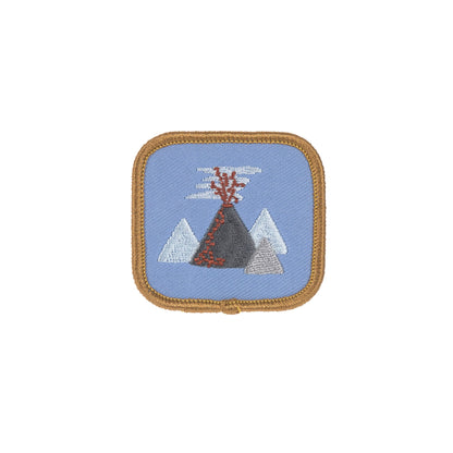Quadratische Patch mit Vulkan-Motiv auf blauem Hintergrund aus dem Laessig Dinosaurier Set.