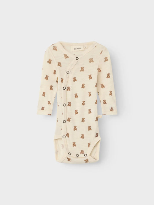 Baby trägt den Wickelbody von Lil' Atelier mit süssem Teddymuster – ideal für sensible Haut.
