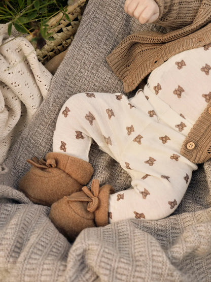Gemütlich eingekuscheltes Baby im Lil' Atelier Wickelbody mit süssen Bären – aus Winterthur, Zürich, Schweiz.