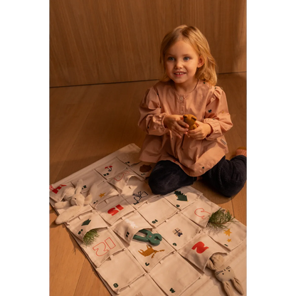 Kind spielt neben dem Liewood Babbo Adventskalender Sandy auf dem Tisch