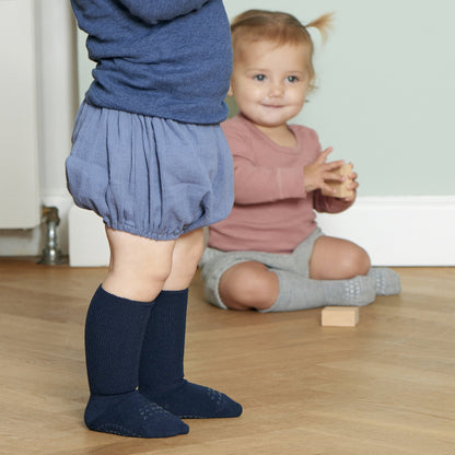 Baby in Bewegung mit navyfarbenen Anti-Rutsch-Socken von GoBabyGo – ideal für erste Schritte